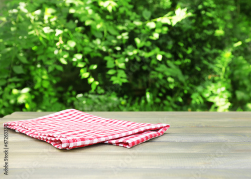 Wooden table with tablecloth, outdoors
