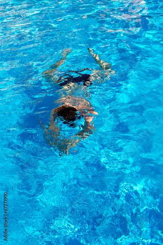 man swims breaststroke under water in the pool