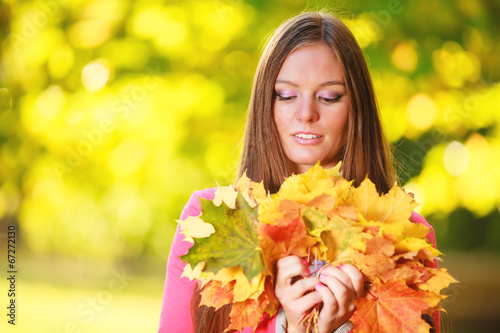 Fall season. Portrait girl woman with bunch of autumnal leaves
