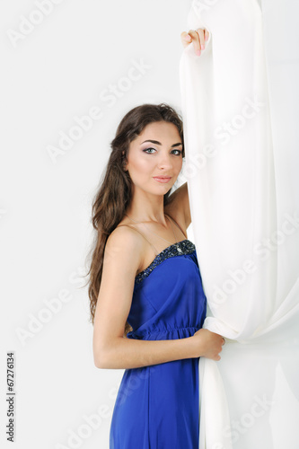 Girl near curtains posing in studio