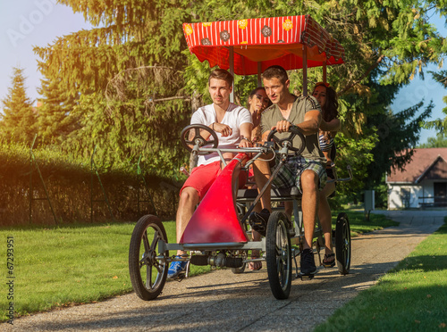 four young people in a four-wheeled bicycle © Zsolnai Gergely