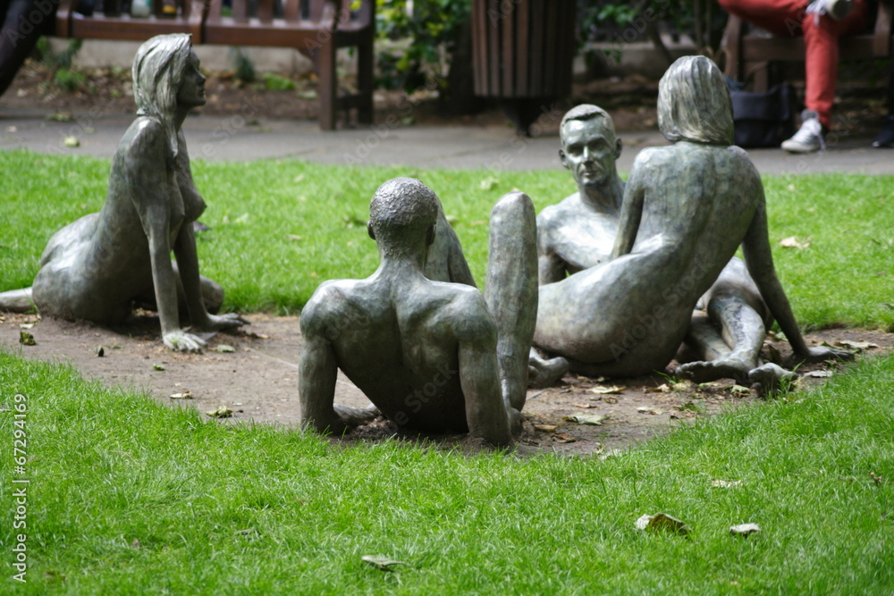 Obraz premium Reclining Nude Sculptures in park grass