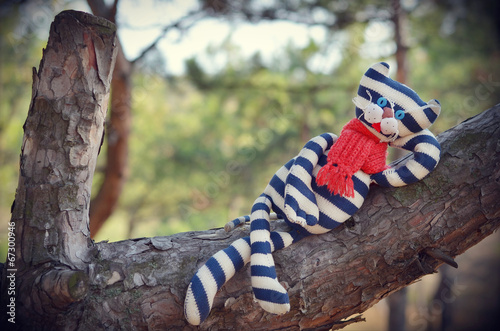 Cute toy cat resting on a tree