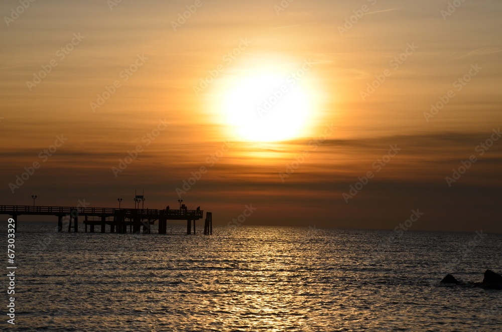 Angler auf Seebrücke bei Sonnenuntergang