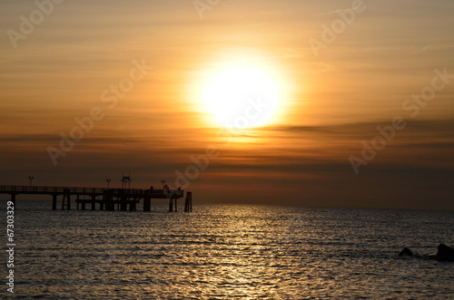 Angler auf Seebrücke bei Sonnenuntergang