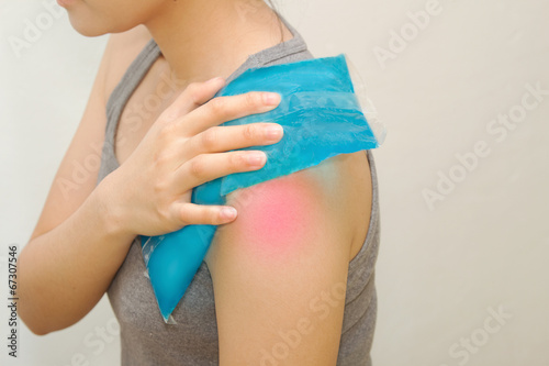 woman applying cold pack on swollen hurting shoulder © praisaeng