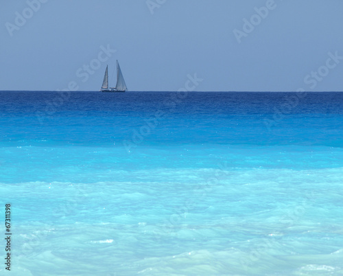 sailboat with a white sail, blue Mediterranean sea