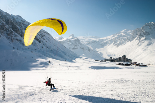 Paraglider landing on skis in Tignes, French Alps