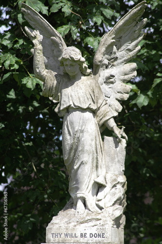  stone statue of woman angel with wings in cemetery 