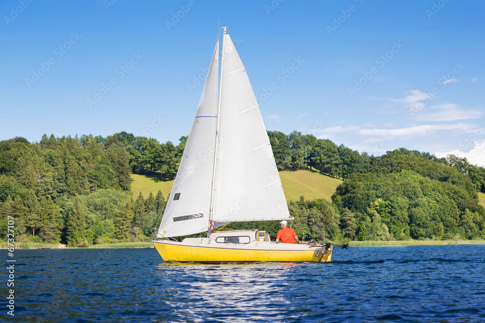 Fototapeta premium Yellow sail boat on the lake