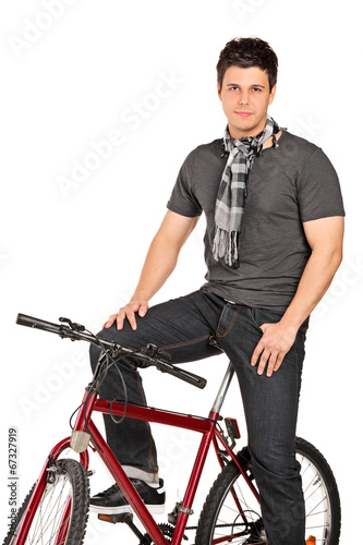 Man with scarf posing seated on a bicycle