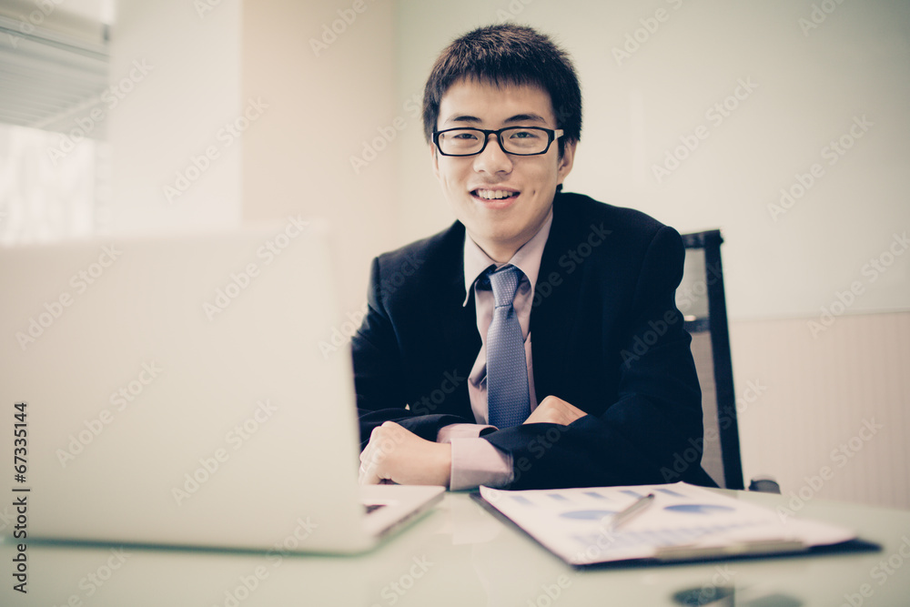 Young handsome man using laptop in his office