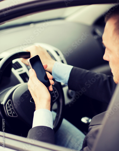 man using phone while driving the car © Syda Productions