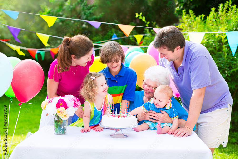 Happy young family with grandmother at birthday party - obrazy, fototapety, plakaty 