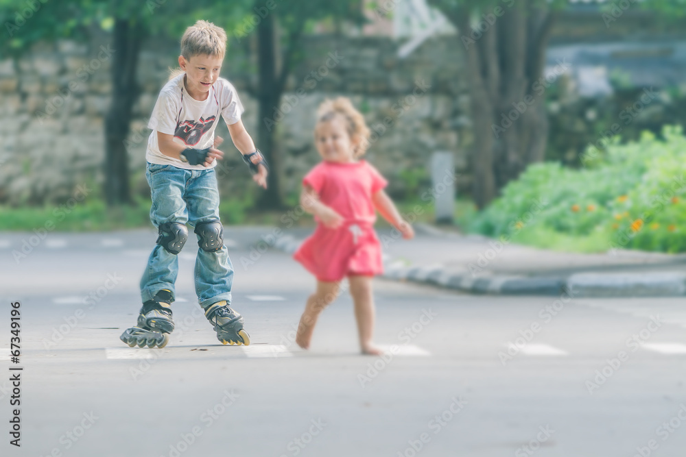 young happy boy faving fun on roller scates on natural backgroun young happy boy faving fun on roller scates on natural backgroun