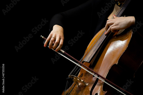 Foto Hands girl playing cello on a black background