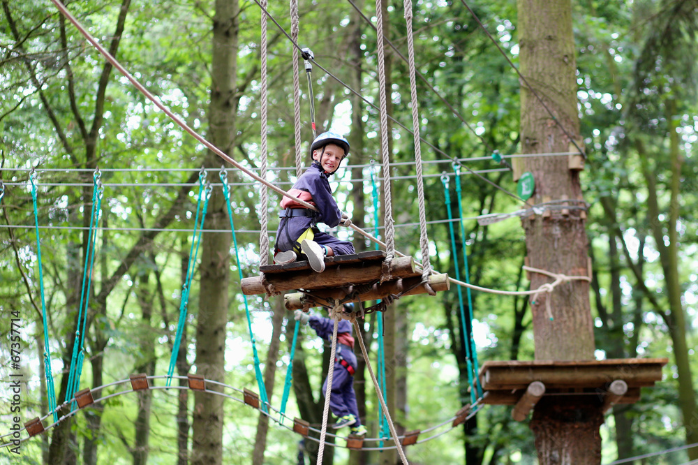 Happy boy enjoying a climbing adventure in activity park Happy boy enjoying a climbing adventure in activity park