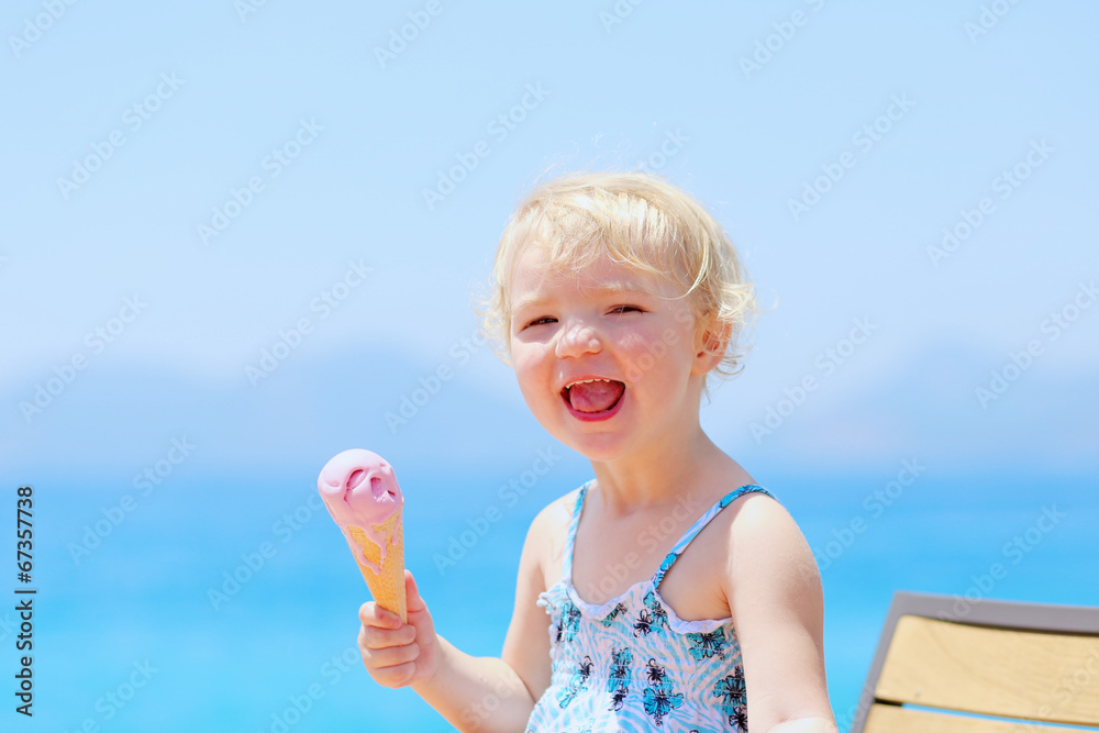Happy little girl eating ice cream during summer vacations Happy little girl eating ice cream during summer vacations