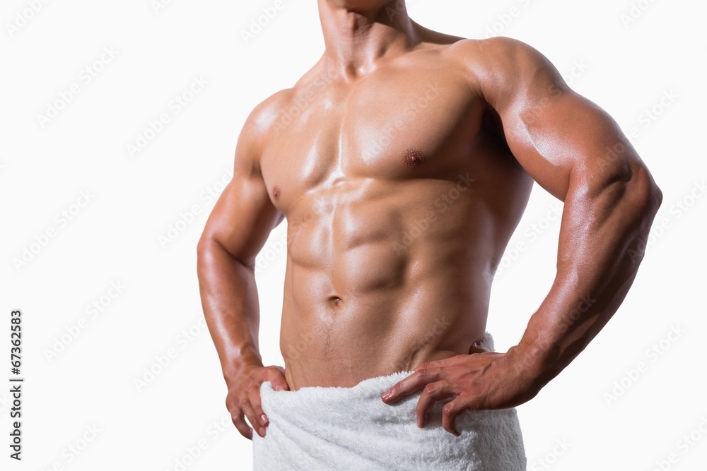 Mid section of a shirtless muscular man in white towel Mid section of a shirtless muscular man in white towel