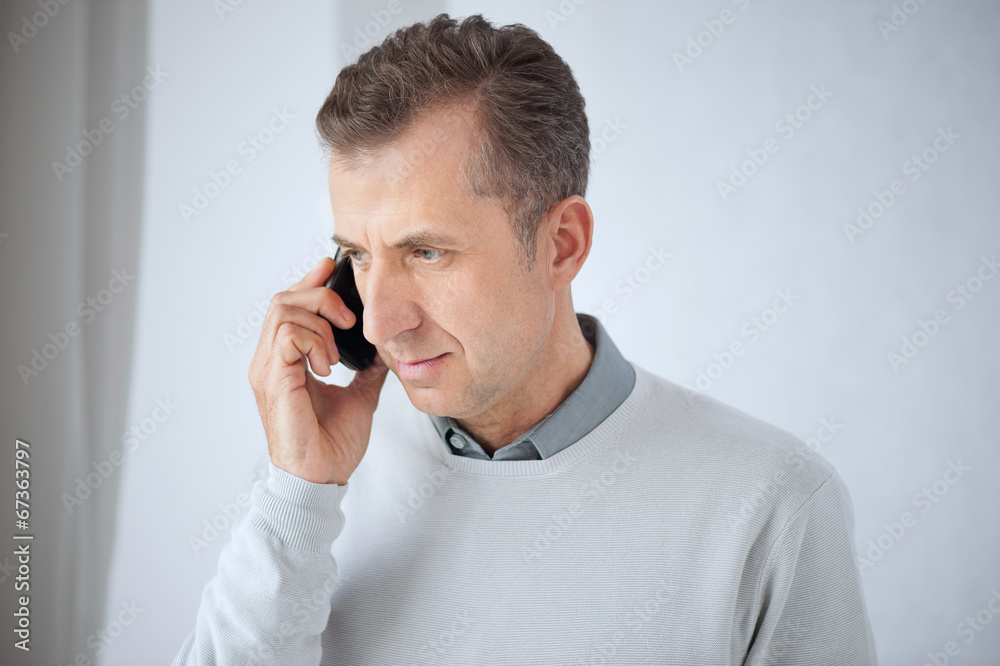 Mature businessman answering smart phone and mobile. Mature businessman answering smart phone and mobile.