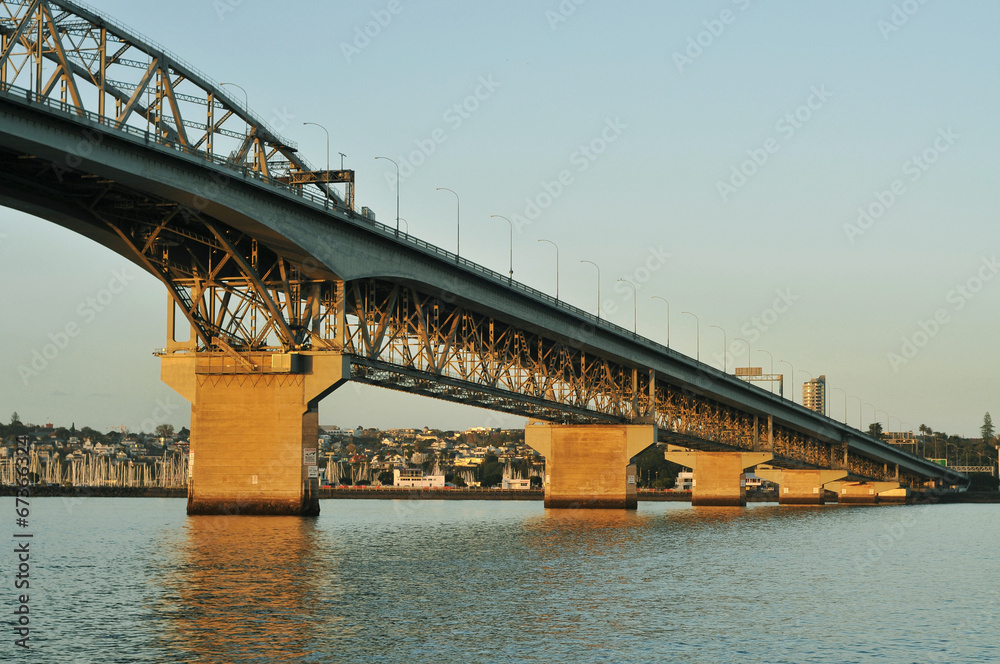 Fototapeta premium Auckland Harbour bridge lit by early morning sun on winter day