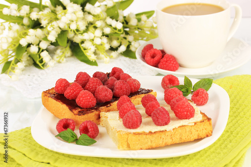 Delicious toast with raspberries on table close-up