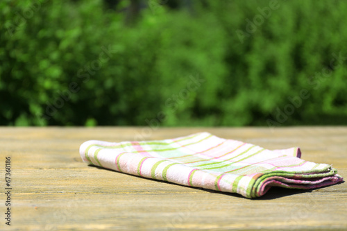 Wooden table with tablecloth, outdoors photo