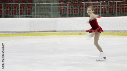 little figure skater girl performing an upright spin