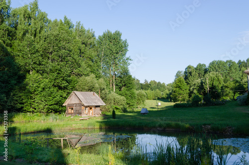 countryside with wooden bathhouse and green nature