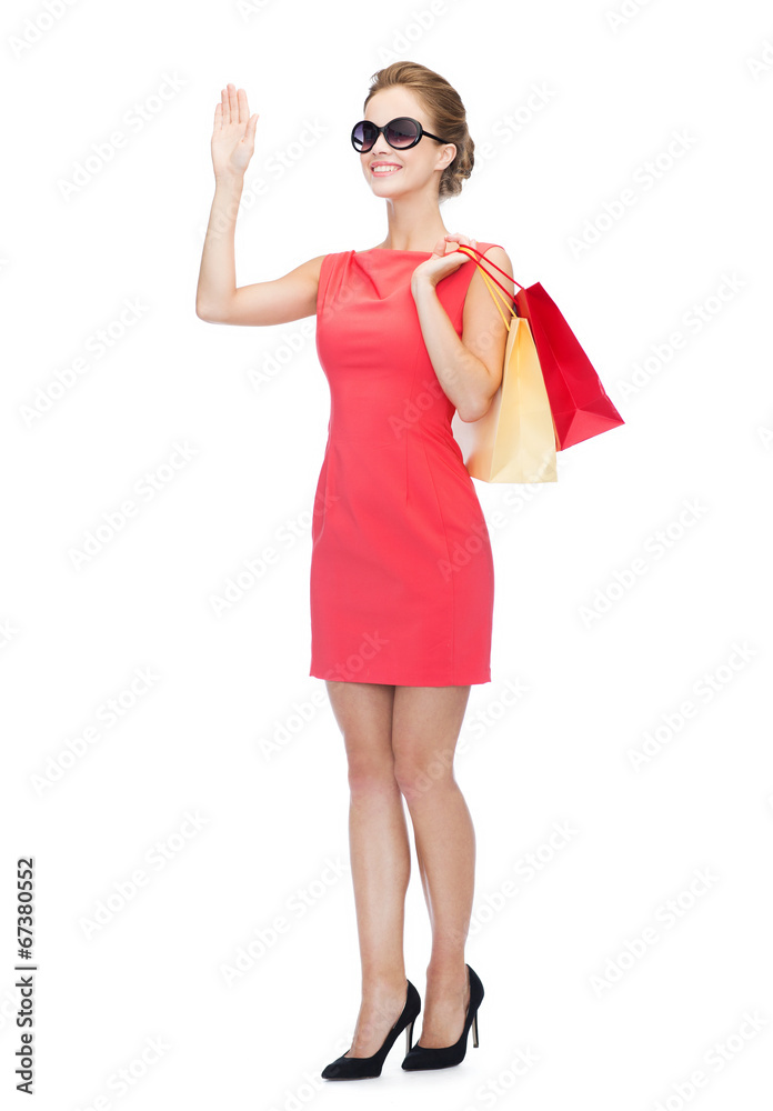 smiling woman in red dress with shopping bags smiling woman in red dress with shopping bags