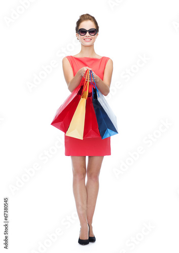 smiling woman in red dress with shopping bags