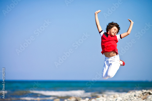 Мальчик в прыжке на берегу моря