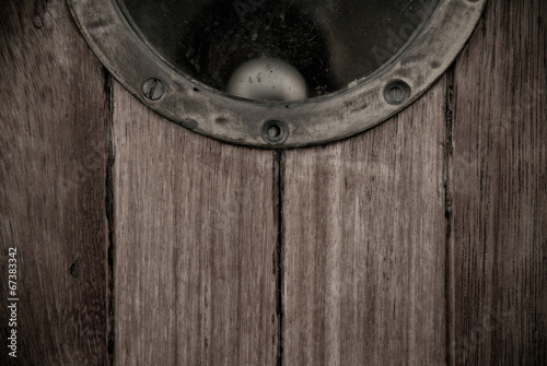 Close-up of a wooden boat closed porthole