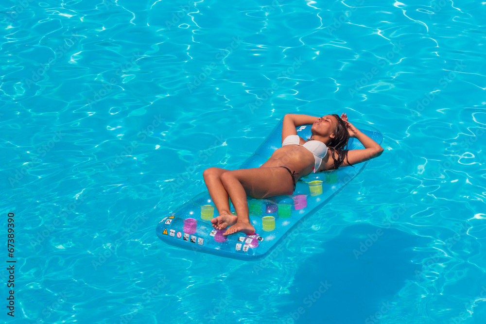 A girl is relaxing in a swimming pool