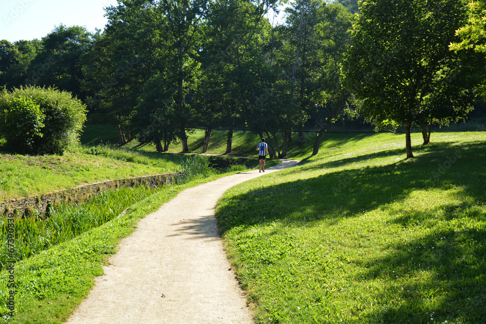 hombre corriendo por un camino en un parque hombre corriendo por un camino en un parque