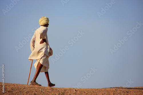 Local man walking on a hill, Khichan village, India photo