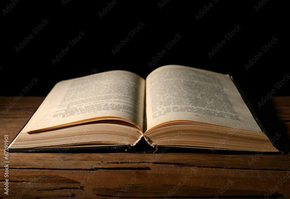 Obraz premium Old book on table on black background
