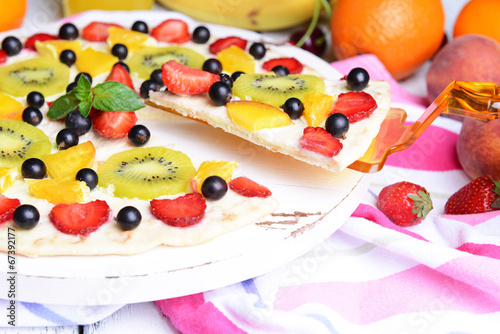 Sweet pizza with fruits on table close-up