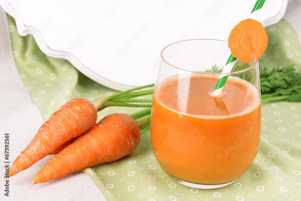 Glass of carrot juice and fresh carrots on table close up Glass of carrot juice and fresh carrots on table close up