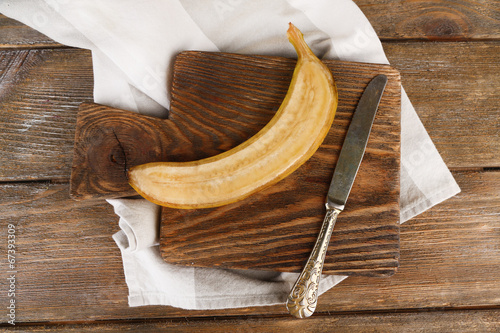 Quadro em tela Halved ripe banana on wooden background