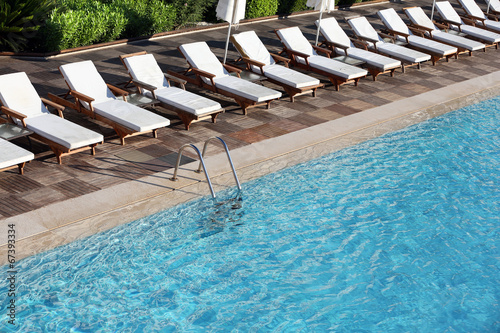 Lounge sunbeds near swimming pool