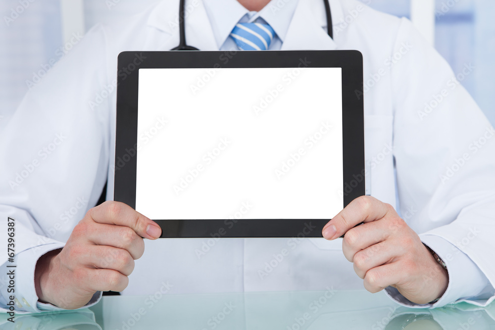 Doctor Displaying Digital Tablet At Desk Doctor Displaying Digital Tablet At Desk