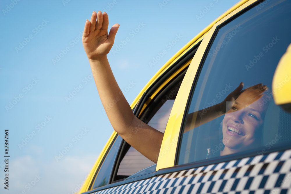 Naklejka premium woman in taxi waving hand out of car window