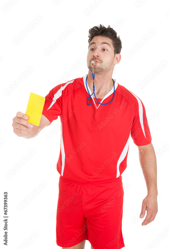 Referee Blowing Whistle While Showing Yellow Card Referee Blowing Whistle While Showing Yellow Card