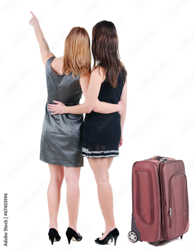 Two young women traveling with suitcas rear view. Two young women traveling with suitcas rear view.