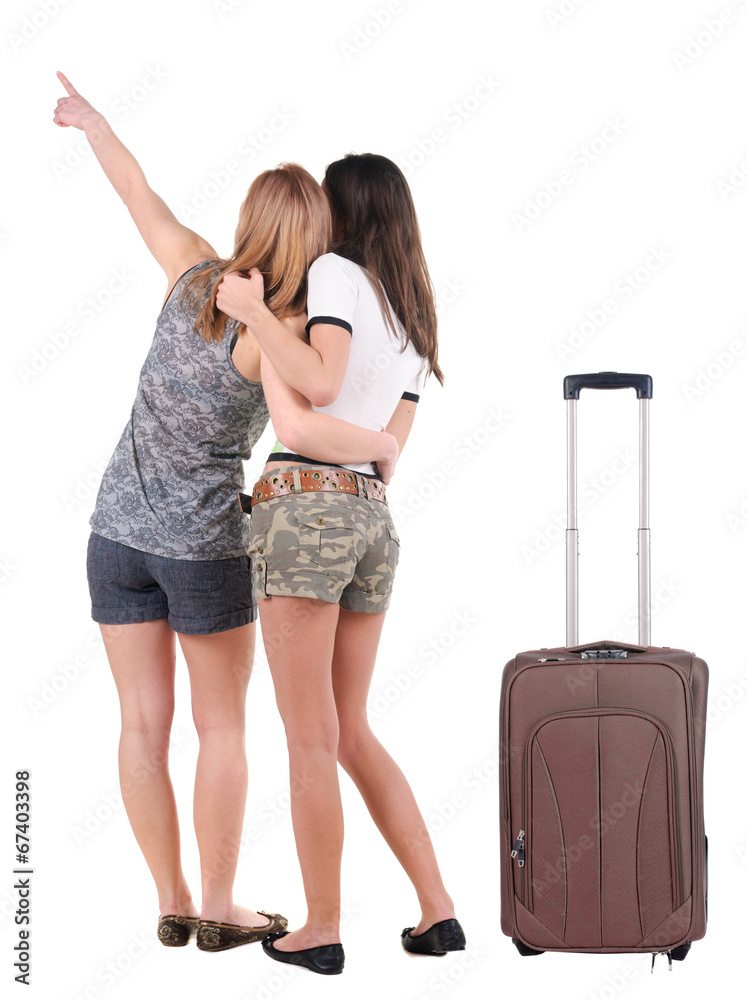 Two young women traveling with suitcas rear view. Two young women traveling with suitcas rear view.