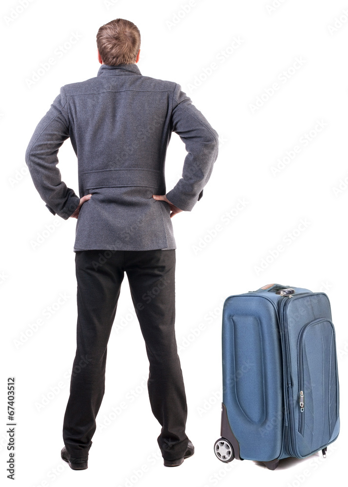 Back view of young man traveling with suitcas. Back view of young man traveling with suitcas.