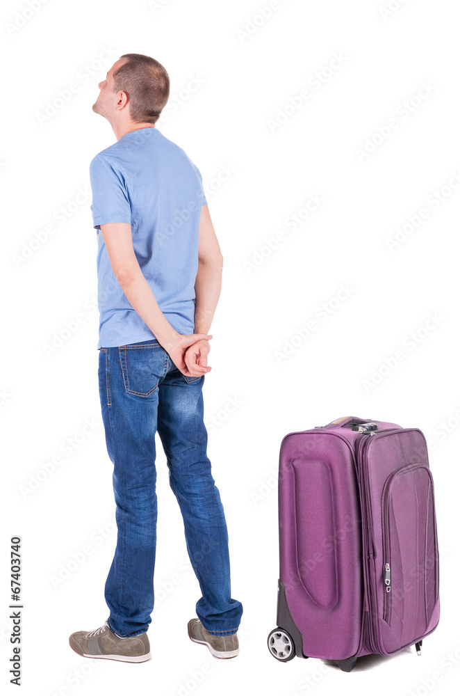 Back view of young man traveling with suitcas. Back view of young man traveling with suitcas.