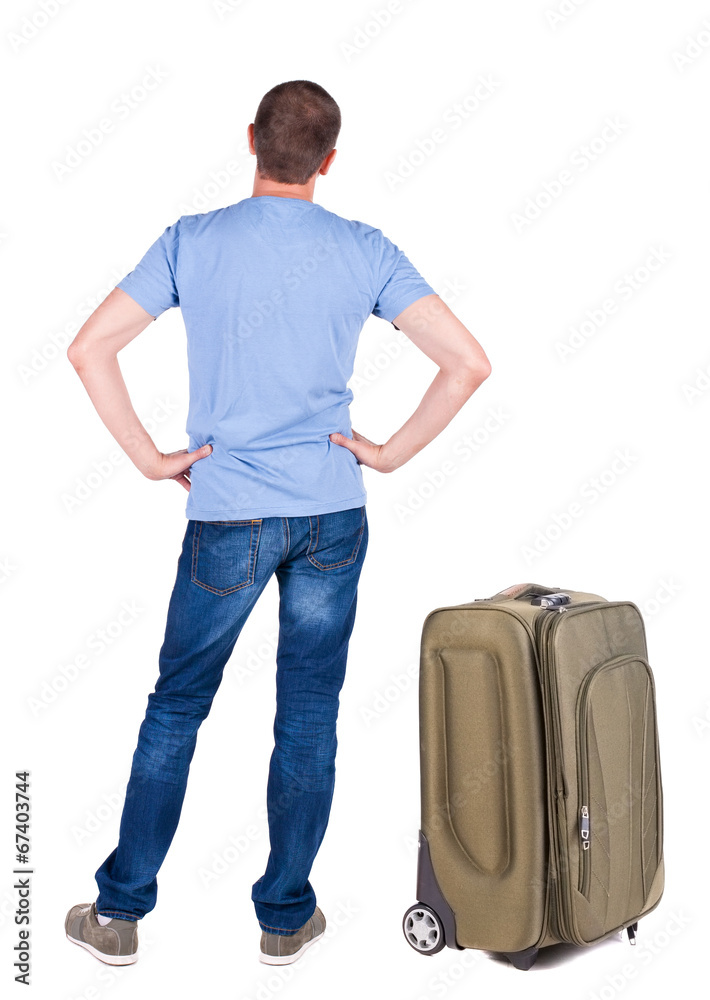 Back view of young man traveling with suitcas. Back view of young man traveling with suitcas.
