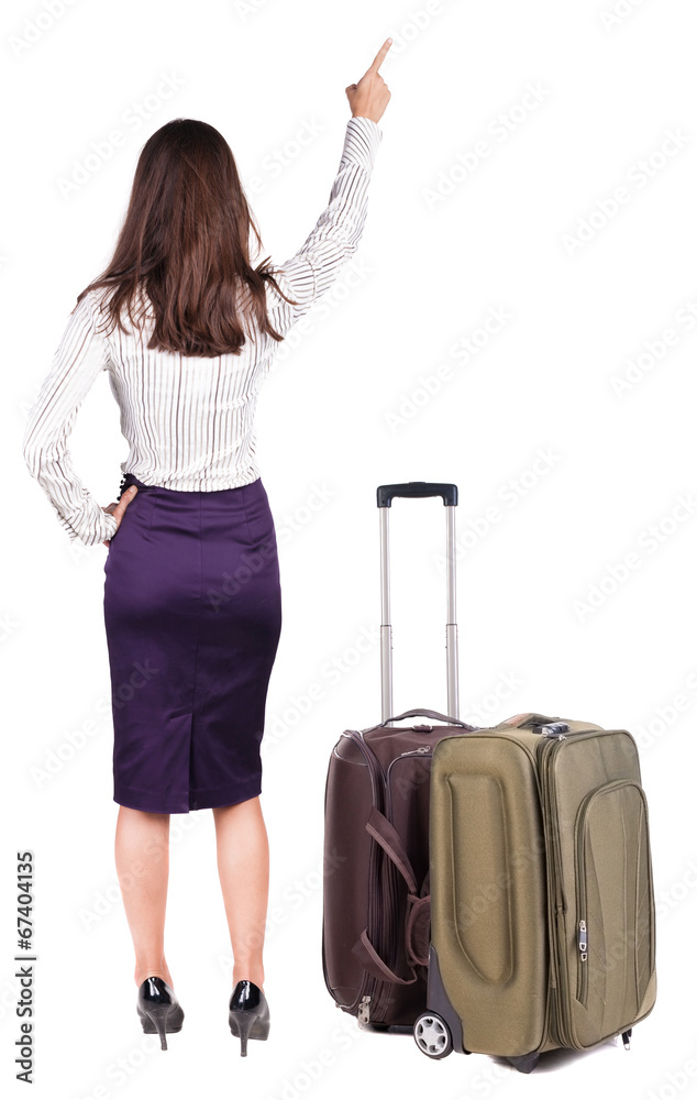 Back view of young brunette woman traveling with suitcas and poi Back view of young brunette woman traveling with suitcas and poi